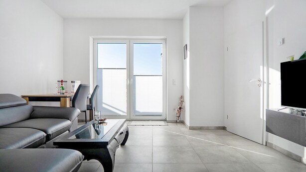 Un salon moderne avec un canapé, une table basse et un téléviseur.