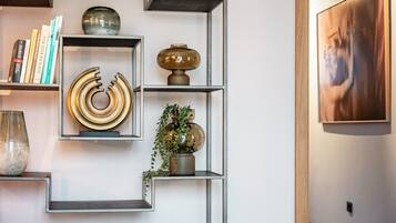 Ein modernes Interieur mit geometrischen Regalen, dekorativen Accessoires und einem gerahmten Kunstwerk an der Wand.