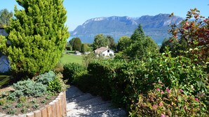 Ein Gartenweg führt zu einem Haus mit Blick auf die Berge.