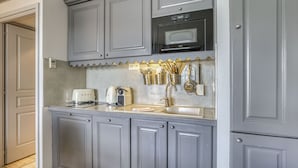 A kitchen with grey cabinets, a microwave, and a coffee maker. - La plage privée du lac (Duingt)