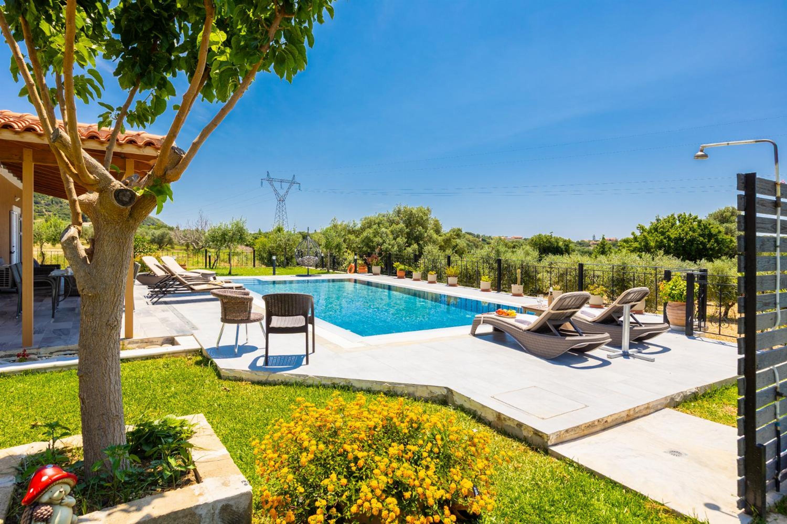 A swimming pool with lounge chairs, a pergola, and a view of the countryside.