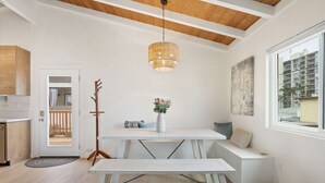 Ein modernes Interieur mit Esstisch, Bank, Pendelleuchte und Blick ins Freie.