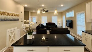 A modern kitchen with a central island, pendant lighting, and a ceiling fan. - Luxury Medical District Home, EV Charger, Gated #10 (Augusta)