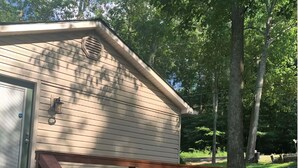 Une petite cabane avec une terrasse en bois et une porte.