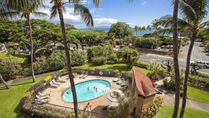 A residential area with a swimming pool surrounded by palm trees and a view of the ocean. - Top Floor Maui Vista with Ocean View, AC, 5min Walk to Beach (Kihei)