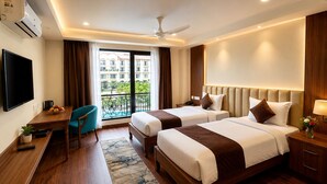 A hotel room with two beds, a desk, a TV, a balcony with a pool view, and an air conditioning unit. - Mystique Mayong  (Mayang)