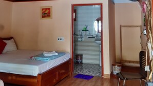 A bedroom with a wooden ceiling, a bed, a chair, a small table, and a fan. - CAT BA PARK HOMESTAY (Hai Phong)