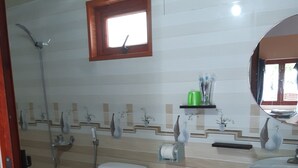 A bathroom with a toilet, bidet, and sink. There is a window above the sink and a mirror on the wall. - CAT BA PARK HOMESTAY (Hai Phong)