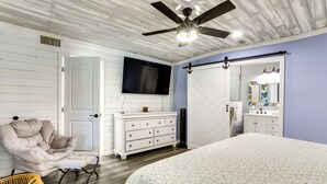 A bedroom with a bed, a TV, a wardrobe, a chair, and a dresser. - Port Charlotte Home w/ Private Dock & Pool! (Port Charlotte)