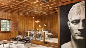 A room with a wooden ceiling, a large painting, a table with chairs, and a window. - Torre delle Cornacchie (Rome)