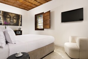 A bedroom with a bed, a chair, a TV, a window, and a painting on the wall. - Torre delle Cornacchie (Rome)