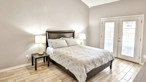 A bedroom with a bed, nightstands, and a door leading to a balcony. - San Antonio Escape. Close to Lackland, SeaWorld, Fiesta Texas, and Riverwalk (San Antonio)