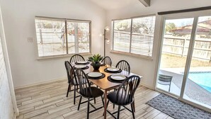 A dining area with a wooden table, black chairs, and a potted plant. - San Antonio Escape. Close to Lackland, SeaWorld, Fiesta Texas, and Riverwalk (San Antonio)