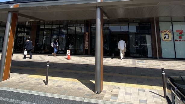En modern byggnad med en inglasad entré, stora glasfönster och en väl synlig skylt för en 7-Eleven-butik.