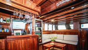 Un interior de madera con una barra, un sofá y un refrigerador.