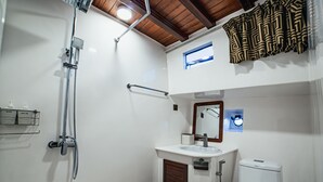 Un baño con ducha, inodoro, lavabo y espejo.