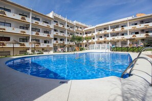 A swimming pool with a 90-meter length, surrounded by a multi-story hotel with balconies and outdoor seating. - Calahonda apartment - all facilities 5 mins walk (Mijas Costa)