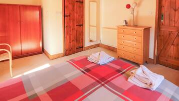 Ein Zimmer mit Schachbrettmuster-Teppich, Holzschrank und Kommode mit Blumenvase.