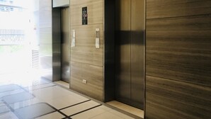 Um elevador moderno com acabamento metálico e painel de controle com botões.
