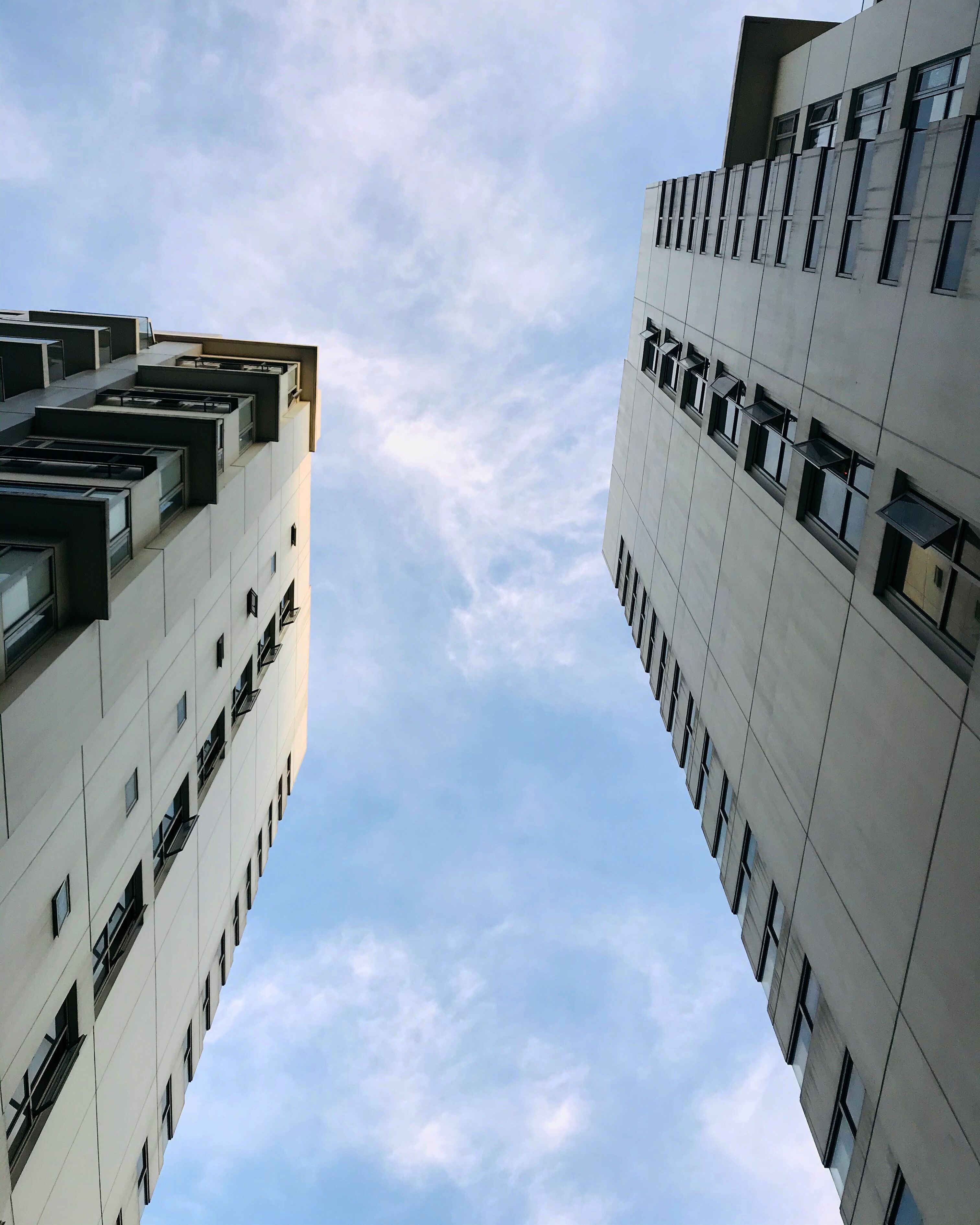 A modern building with a symmetrical facade, multiple windows, and a clear sky in the background.