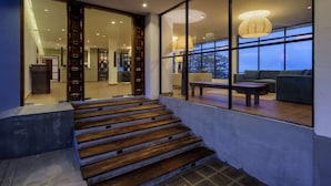 A modern interior with a staircase leading to a living area with a view.