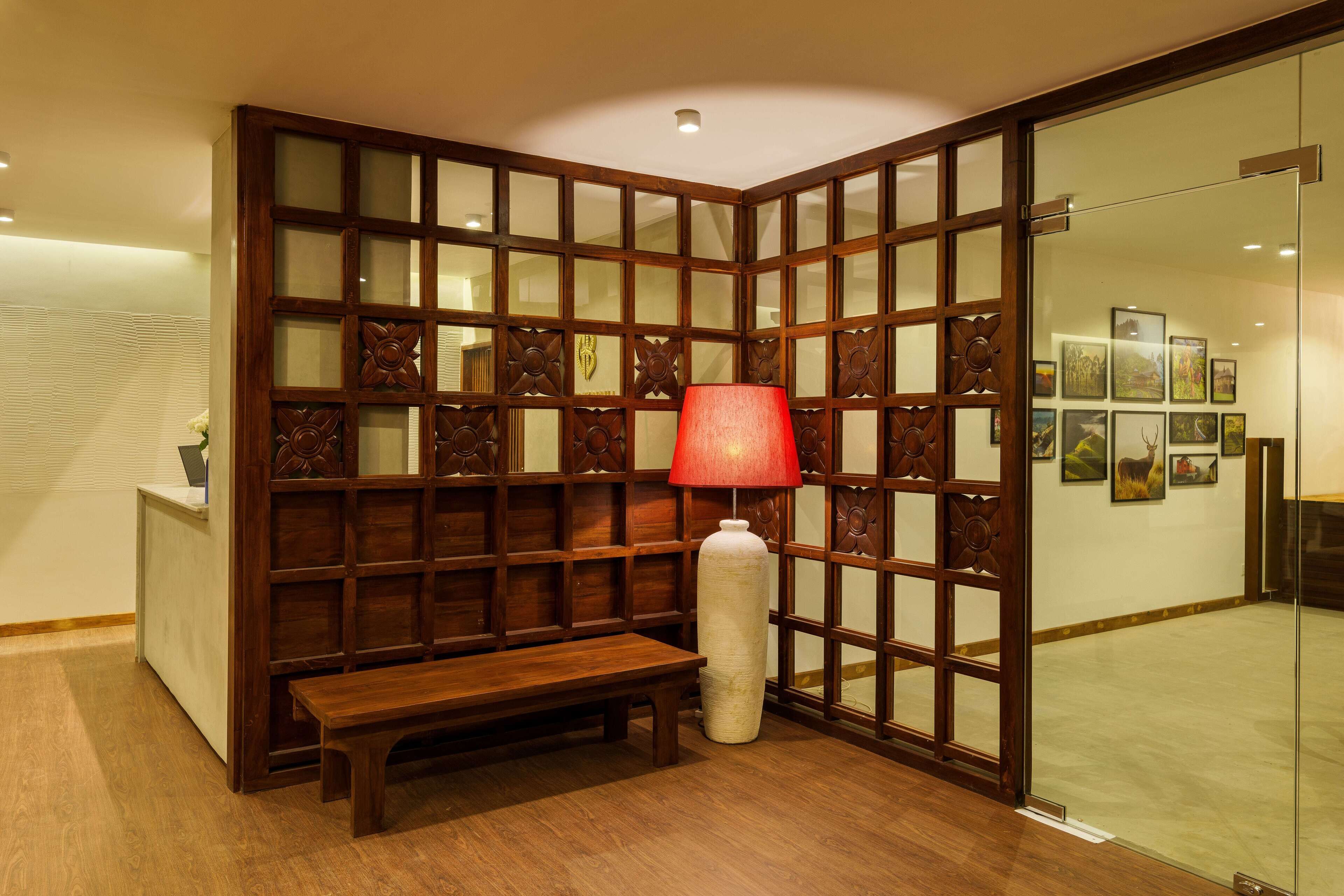 A traditional room with a wooden partition, a bench, and a red lamp.