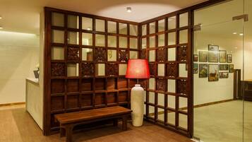 A traditional room with a wooden partition, a bench, and a red lamp.