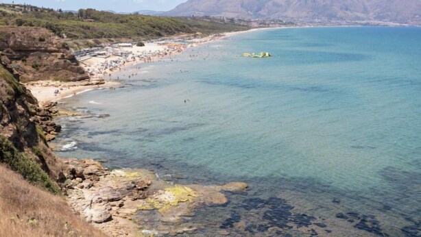 A coastal beach with clear water, rocky shorelines, and distant mountains. - Sicilia by Interhome (Balestrate)