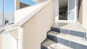Eine moderne Treppe mit geometrischem Design, die zu einem offenen Eingang führt.