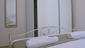 Une chambre à coucher avec un lit, un miroir et une armoire.