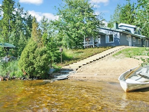 A house with a dock and a boat, surrounded by trees and a clear stream. - Ilotupa by Interhome (Pertunmaa)