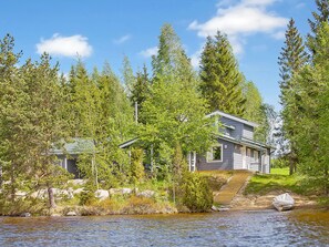 A house by a lake with a wooden dock and a boat. - Ilotupa by Interhome (Pertunmaa)