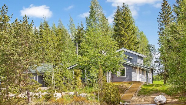 A lakeside cabin with a dock, surrounded by dense forest and a clear sky. - Ilotupa by Interhome (Pertunmaa)