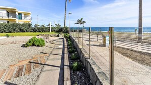 A coastal promenade with a pathway, palm trees, and a view of the sea. - Papagayo San Agustin by Interhome (Maspalomas)