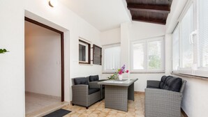 Un espace extérieur aménagé avec des meubles en osier, une table et une plante en pot.