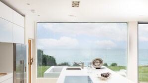 Eine moderne Küche mit einem großen Fenster mit Blick auf ein Gewässer.