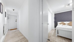 Ein modernes Schlafzimmer mit Bett, Nachttisch und Kopfteil.