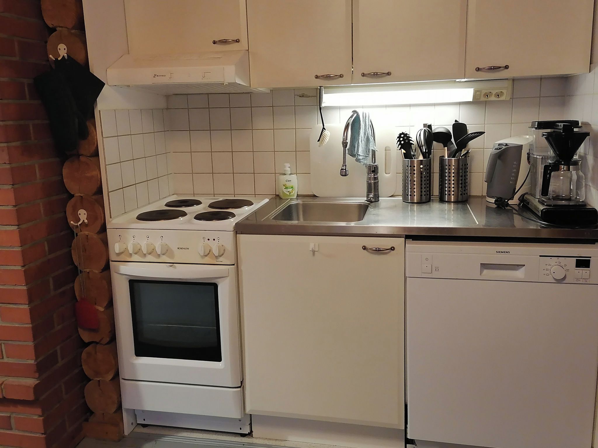 Eine Küche mit Herd, Backofen, Spüle und Geschirrspüler.
