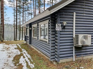 A log cabin with a number sign, a window, and an air conditioning unit.