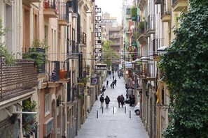 A narrow street with buildings on both sides, a sign for 'MUEBLES S.L.' and a 'Solano' sign. - APARTMENTS BCN CENTRAL-ATICO SANTS (Barcelona)