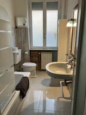 A bathroom with a toilet, sink, and bathtub.