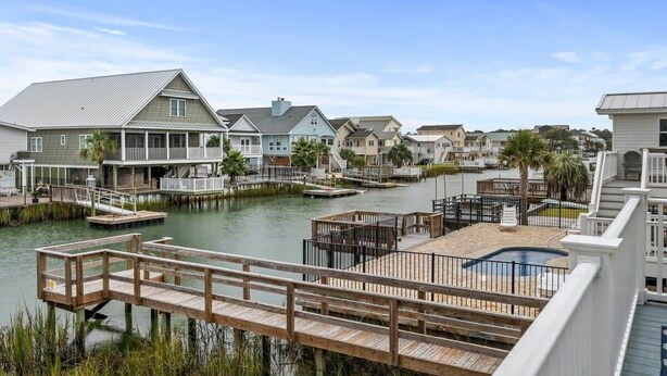 A waterfront property with multiple houses, docks, and a swimming pool. - Fish On - Channel Home Steps To The Beach (North Myrtle Beach)