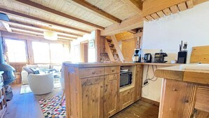 Eine rustikale Küche mit Holzschränken, einem eingebauten Ofen und einer Kaffeemaschine.
