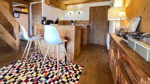 Eine rustikale Küche mit Holzbalken, einem Schachbrettfußboden und einer Bar mit Hockern.