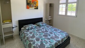Une chambre à coucher avec un lit, une armoire, un miroir et une fenêtre.