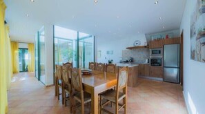 Een ruime keuken met houten kastjes, een centraal eiland en een groot raam.