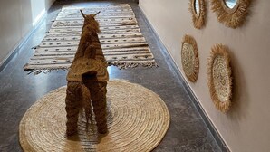 A hallway with a large window, a woven rug, and several wall-mounted mirrors. - Le Figuier du lac (Bine el Ouidane)