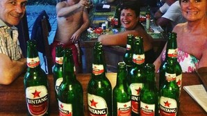 Un grupo de personas en un bar con varias botellas de cerveza Bintang.