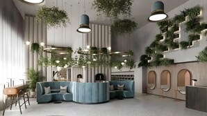 Een modern interieur met een gebogen blauwe bank, hangplanten en een receptiebalie.
