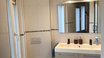 Une salle de bain moderne avec des toilettes, un lavabo et un miroir.